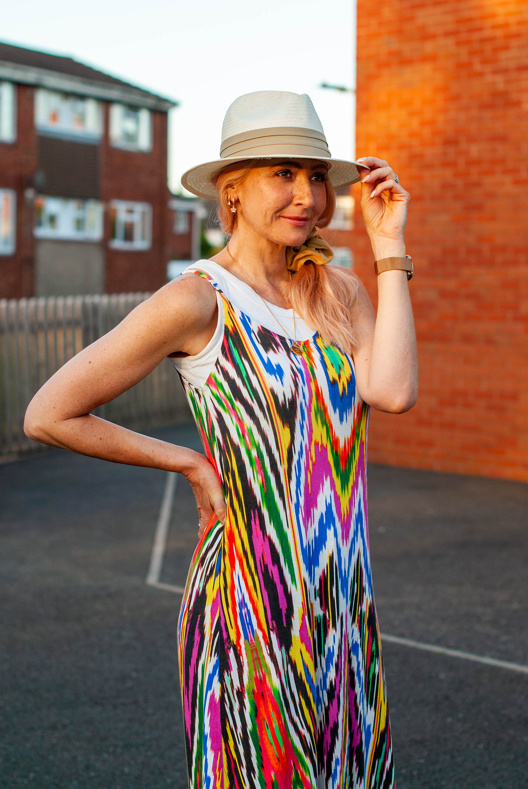 Layering a Rainbow-Explosion Maxi for Summer: Catherine Summers AKA Not Dressed As Lamb wearing an ikat-print multi-coloured maxi with white vest top, Panama hat, navy chunky sandals and an Orla Kiely backpack | Style over 40