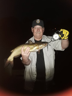 Photo of man holding up a channel at night.