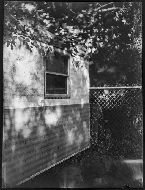 shed, deep shadows, metal fence, yard, Asheville, NC, Fotokor 1, VOOMP Anastigmat Ortagoz 135mm f-4.5, Fomapan 100, Ilfosol 3 developer, 6.15.21