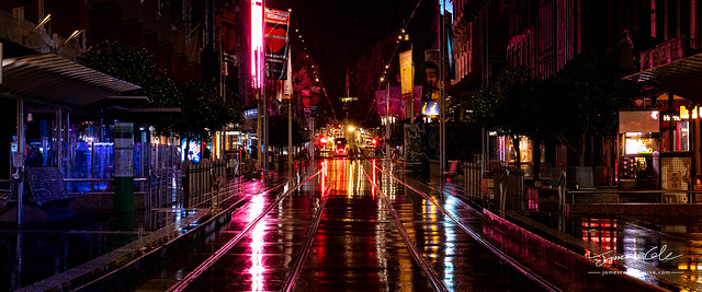 Melbourne City Bourke street mall tramlines on a wet night full of blurry reflections