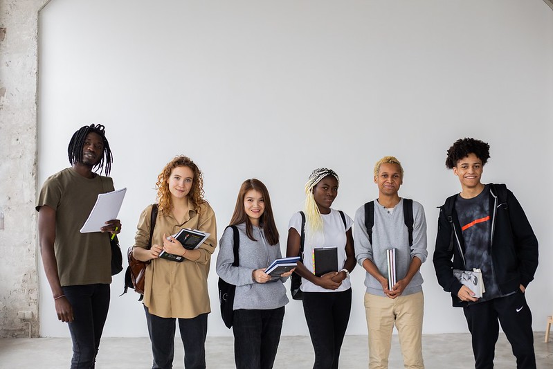 A diverse group of students in a white backdrop