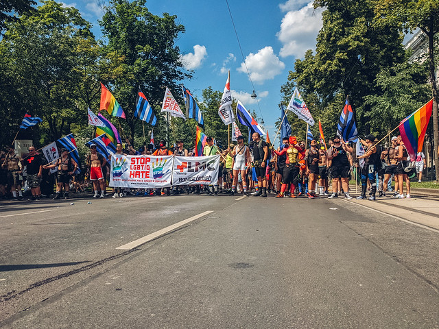 People gathering on the streets with flags and banners supporting Pride parade