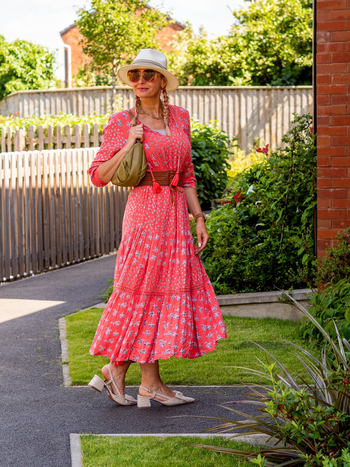 Catherine Summers AKA Not Dressed As Lamb wearing boho coral maxi summer dress, slingback bow-front mules, brown plaited belt, cream Panama hat and pink and orange 1970s-style oversized sunglasses