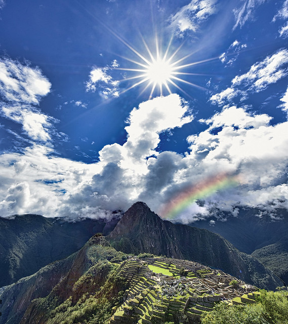 “The sun and a rainbow over …” Machu Picchu Peru