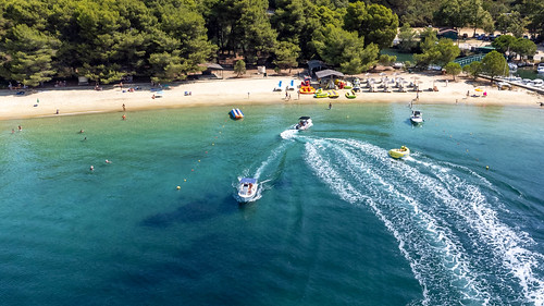 Fun at sea: motorboats and aquadonuts in front of the beach Chrysi Ammos on Skiathos, Greece
