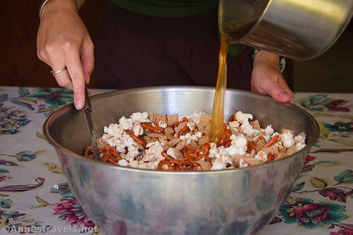 Pouring in the caramel mixture on the Caramel Corn Snack Mix, gluten free, dairy free