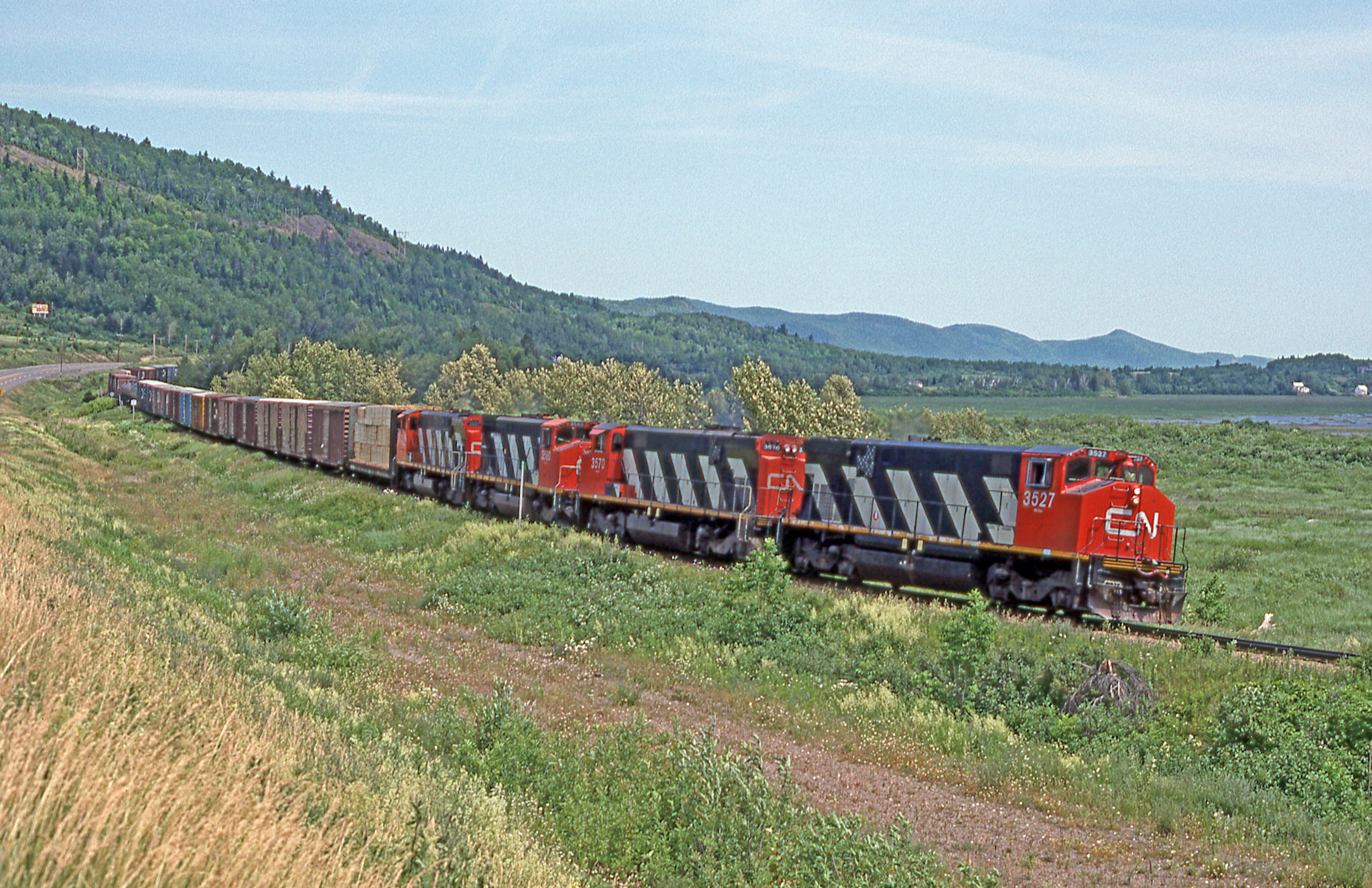 A heavy train off the Gaspé:
Canadian National train # 595 is closing in on Matapedia on a beautiful summer day in 1991. Apparently it's been a productive week along the Gaspé line given that four 3500s have been assigned for the run to Campbellton.  

Restigouche, Quebec
Saturday, July 6, 1991