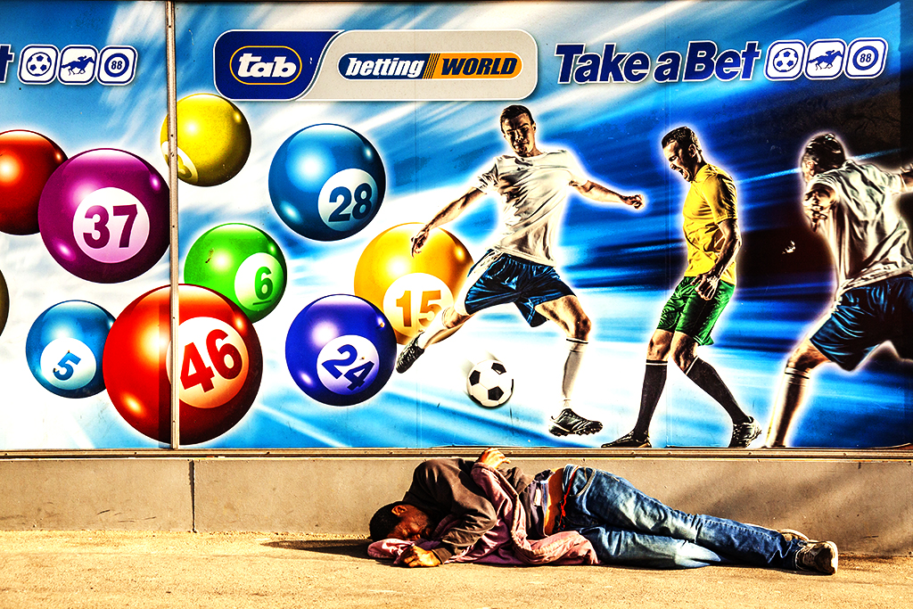 Man sleeping on sidewalk outside betting parlor on 8-7-21--Cape Town