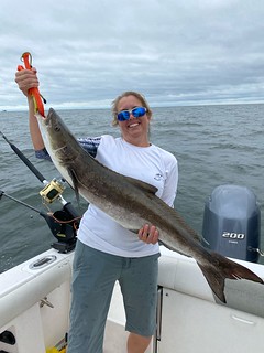 Photo of woman on a boat holding a cobia