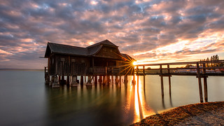 a lonely boathouse at a brilliant sunset