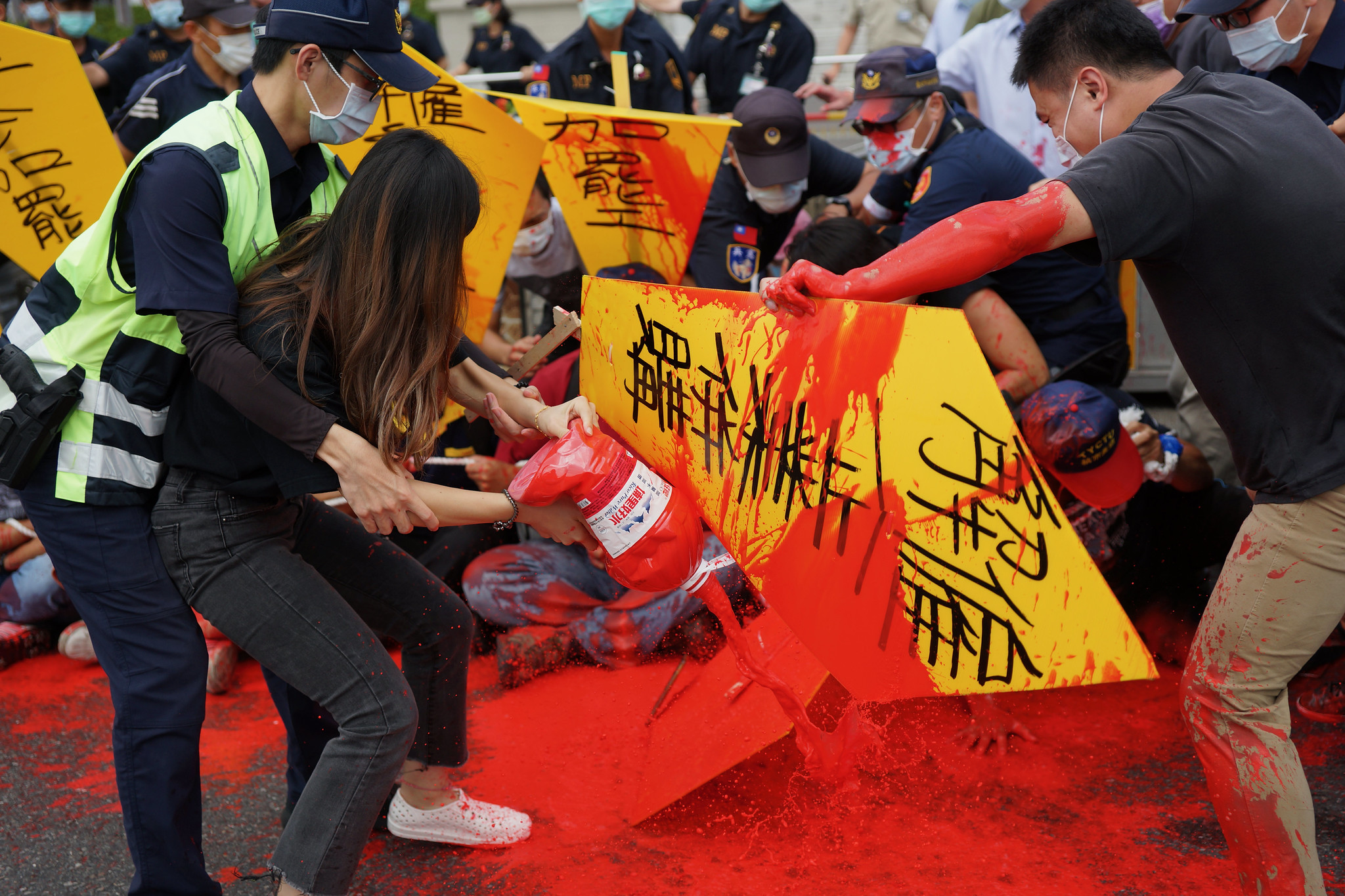 美麗華工會上午在府前拉起人鏈靜坐並於自身淋上紅漆，警方出動兩三百人將工會驅離現場。（攝影：王顥中）