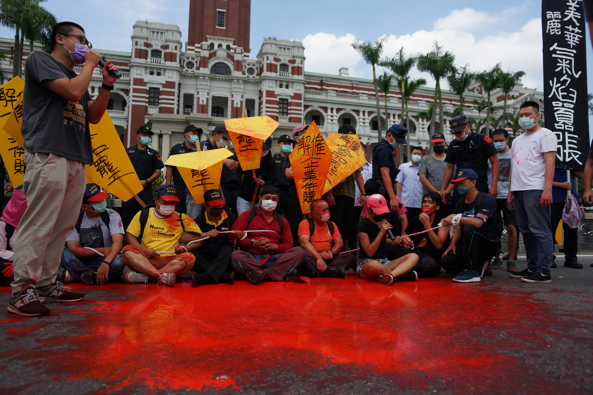 美麗華工會在府前拉起人鏈靜坐並於自身淋上紅漆。（攝影：王顥中）