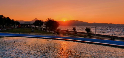 View from the fountain by Ioannis Ks, Sunset view at the seafront of the city of Heraklion, Cretefountain sea water trees sunset mountains