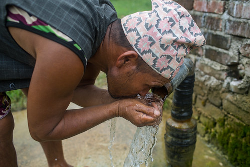 Drinking water from artesian water source that is installed on Fish ponds at Modern Karnali Agro in Nepal