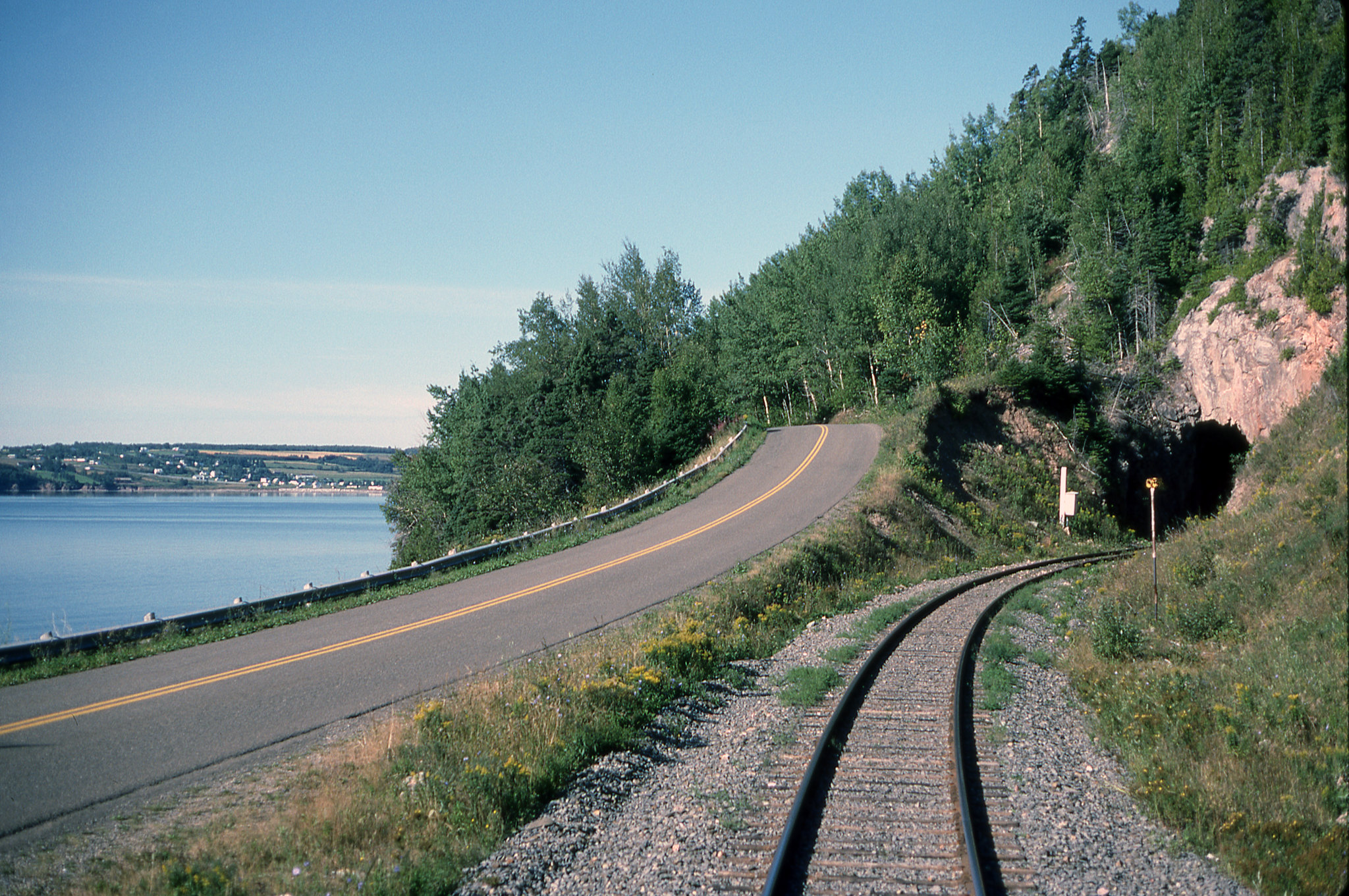 Tunnel just east of Port-Daniel on CN's Gaspé line. 

I took this photo from the rear coach of VIA # 16 "Chaleur" in August 1989. At this time # 16 was combined with # 14 "Ocean" from Montreal to Matapedia. At Matapedia the two trains were split before continuing to their respective destinations, the Ocean to Moncton and the Chaleur to Gaspé. After the infamous cuts of January 1990 the two trains ran on alternate days from Montreal to their respective destinations, six days a week.

Port-Daniel, Quebec
Tuesday, August 8, 1989

