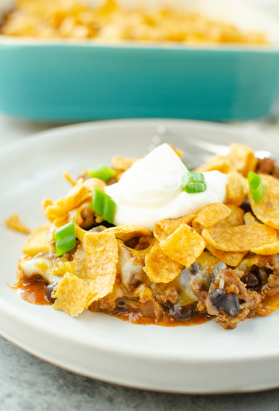 Frito Pie Casserole - layers of crunchy Fritos, seasoned ground beef, black beans, enchilada sauce, and cheese all baked together! Easy, delicious 30 minute dinner! 