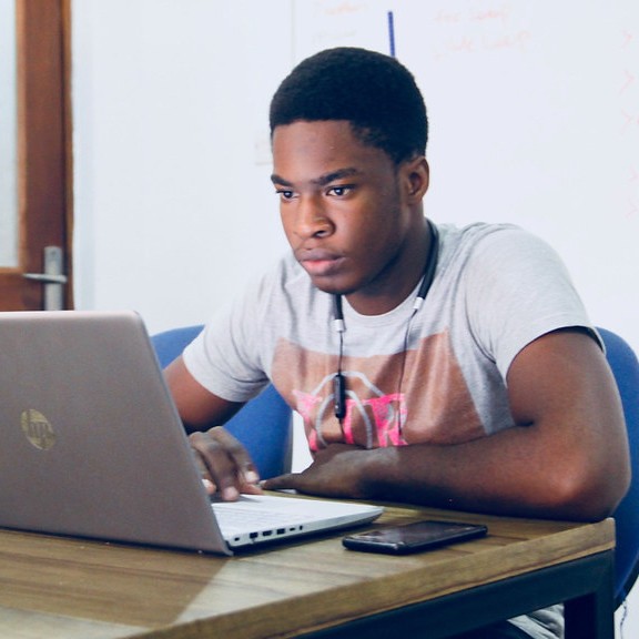 A male black student sat using a laptop