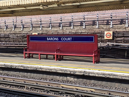 Barons Court Station platform bench & running in board combo.