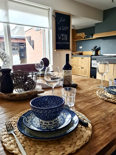 landelijk gedekte tafel met rotan placemat en blauw servies