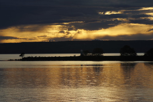 Aurum world by J. Roseen, Golden reflections off the lakeaurum gold sky clouds water reflections lake vättern visingsö västerg