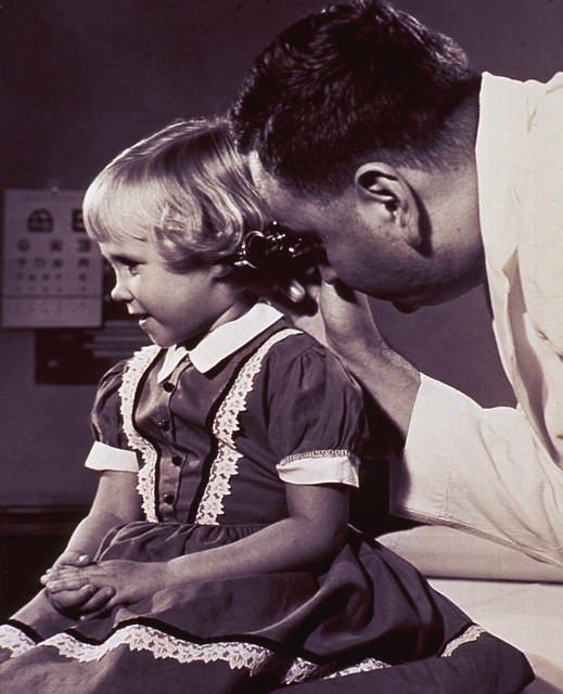 Physician examining the ear of a child
