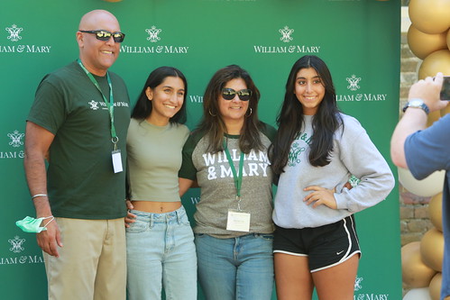 Family members pose for a photo together in front of a W&M background.