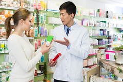 Glad client asking pharmacist about medicines