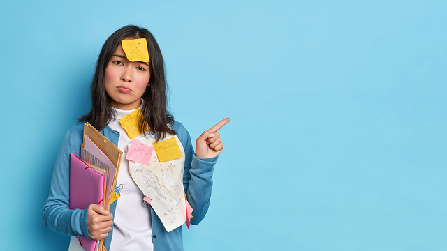Horizontal shot of unhappy brunette Asian woman holds folders with papers gives recommendations how