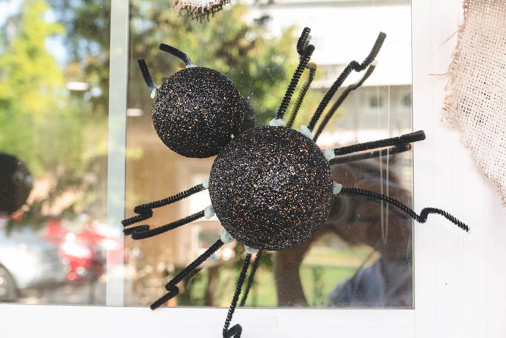 A Halloween spider decoration attached to a window. 