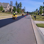 Asphalt Overlay. Paving the final lift of Hot Mix surface asphalt on a subdivision road.