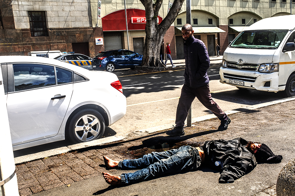 Man lying on sidewalk on Plein Street on 10-17-21--Cape Town