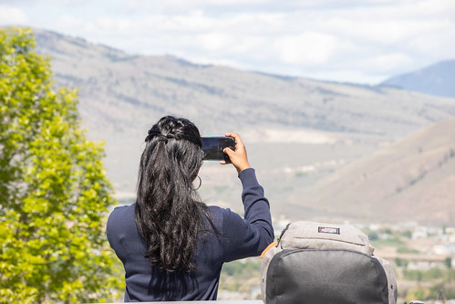 Student taking photo of mountains from edge of campus