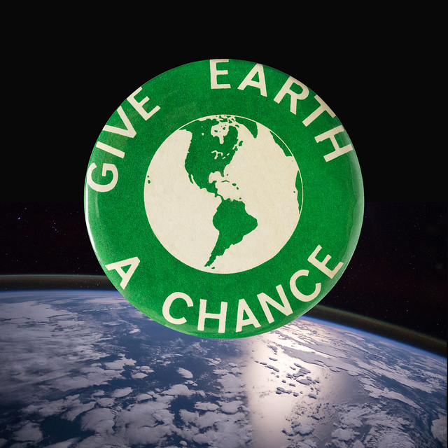 1970 Green Earth Day Button floating over the planet Earth