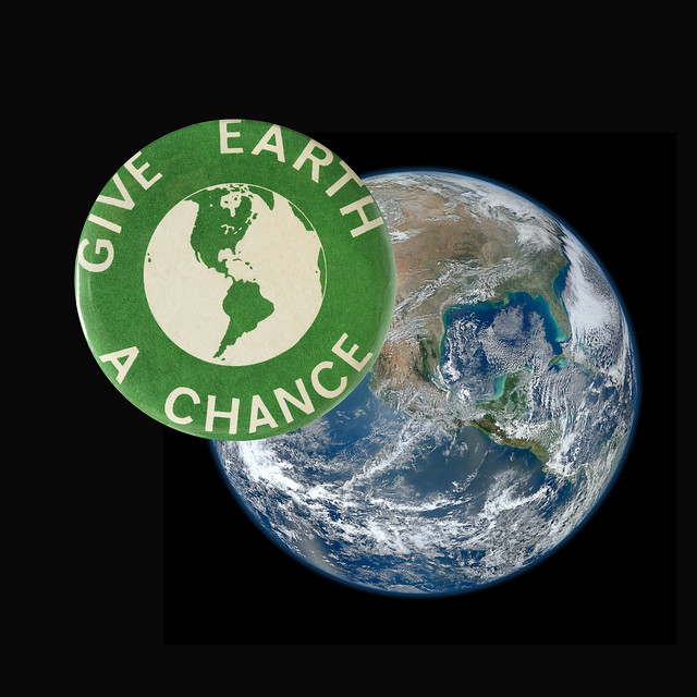 1970 Green Earth Day Button floating over the planet Earth