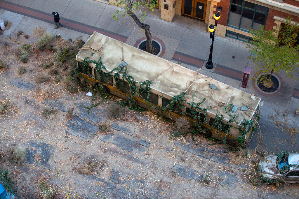 A bus and car overgrown with vines on the production set of HBO's The Last of Us