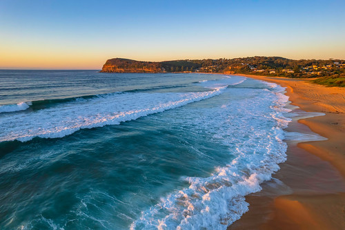 Surfs up aerial sunrise seascape by Merrillie, Sunrise seascape with clear skies and waves at Copacabana on the Central Coast, NSW, Australia.copac