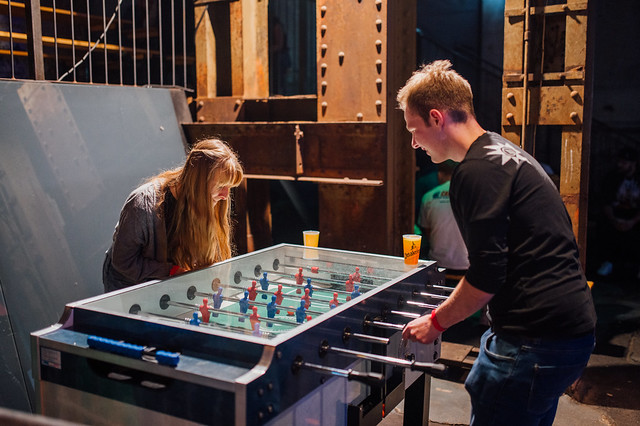 Two friends playing table football and smiling