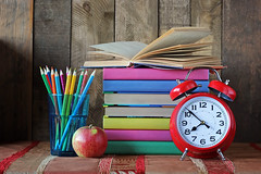 Alarm clock, pencils and a stack of books. Back to school.
