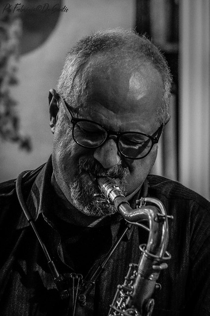 A man breathes deep into saxophone