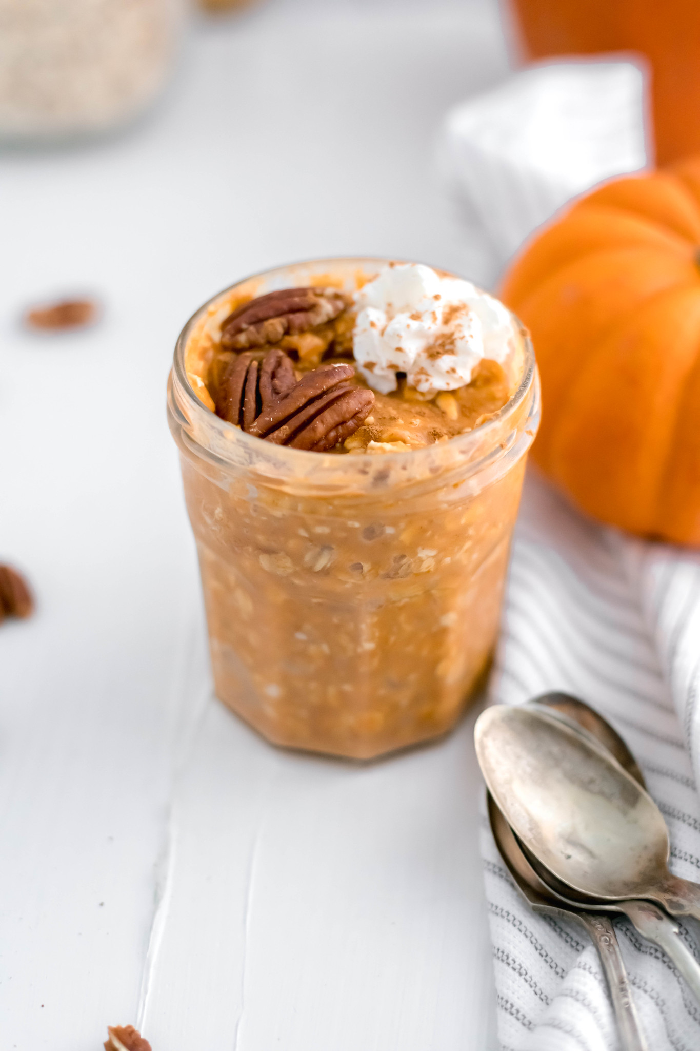 Jar of pumpkin oatmeal with spoons in lower right corner.
