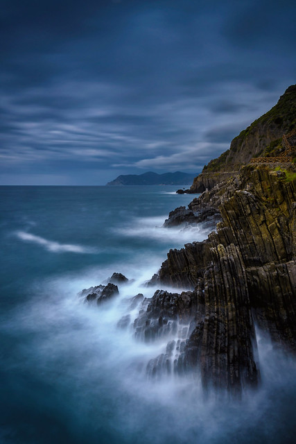 Long exposure of waves splashing on the rocky shore of Riomaggiore, Cinque Terre, Italy
