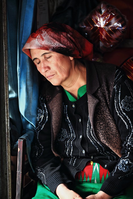 Middle-aged Uyghur saleswoman napping at the city's Sunday market. Hotan-Xinjiang-China-0097