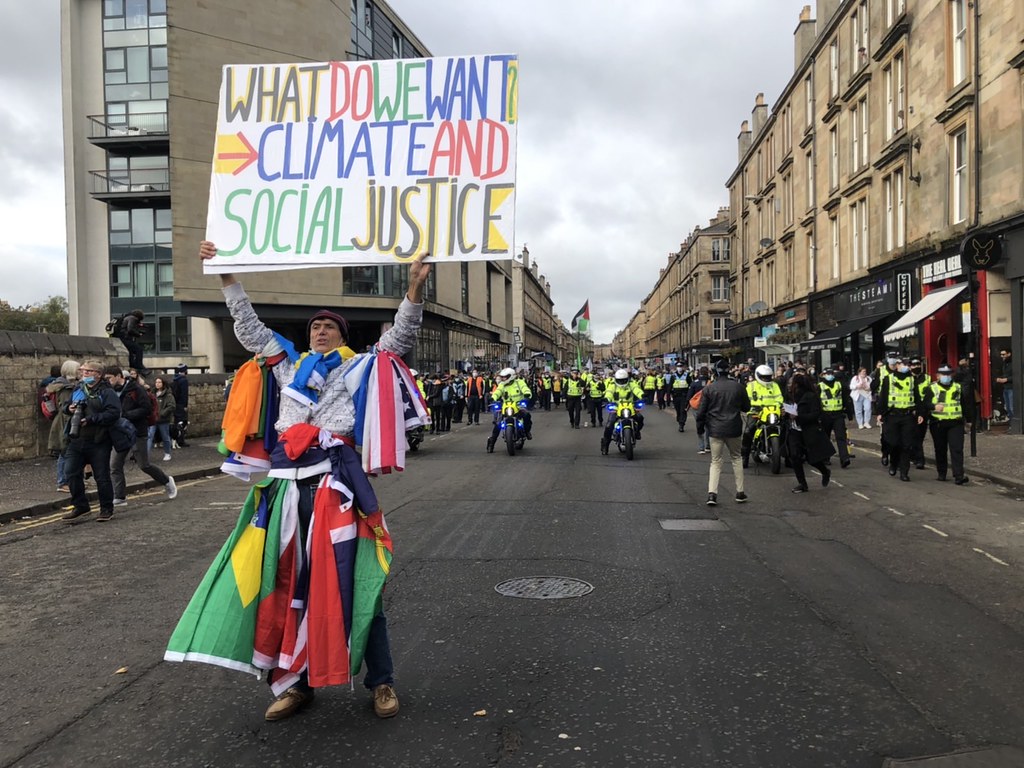 一名來自法國的抗議者高舉標語支持氣候正義。攝影：張語羚。