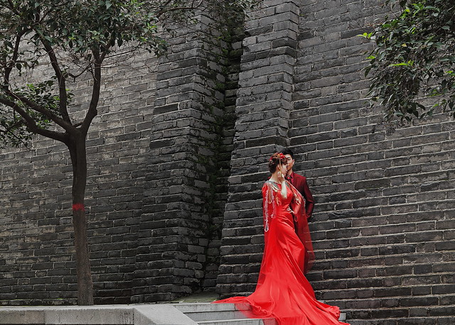 Chinese bride and groom in red wedding outfit at the foot of the city wall. Xi'an-China-1585