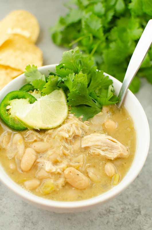 white chicken chili topped with jalapeno slices, a lime wedge, and fresh cilantro