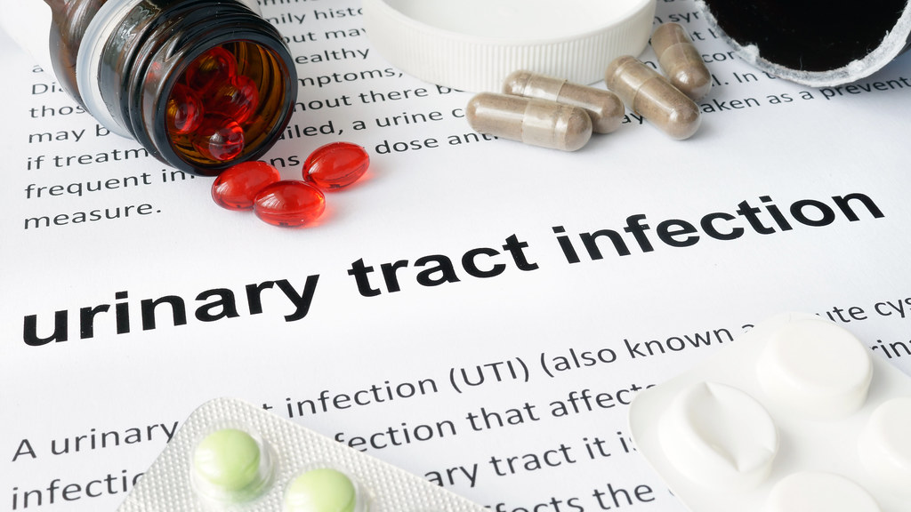 Medical text about urinary tract infections, with pills scattered across the page