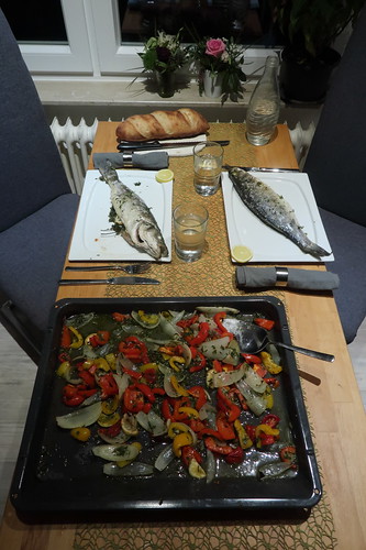 Wolfsbarsche mit mediterranem Gemüse und Weißbrot (Tischbild)