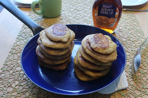 Servierbereite Pumpkin Pancakes (= amerikanische Kürbis-Pfannkuchen) mit Ahornsirup
