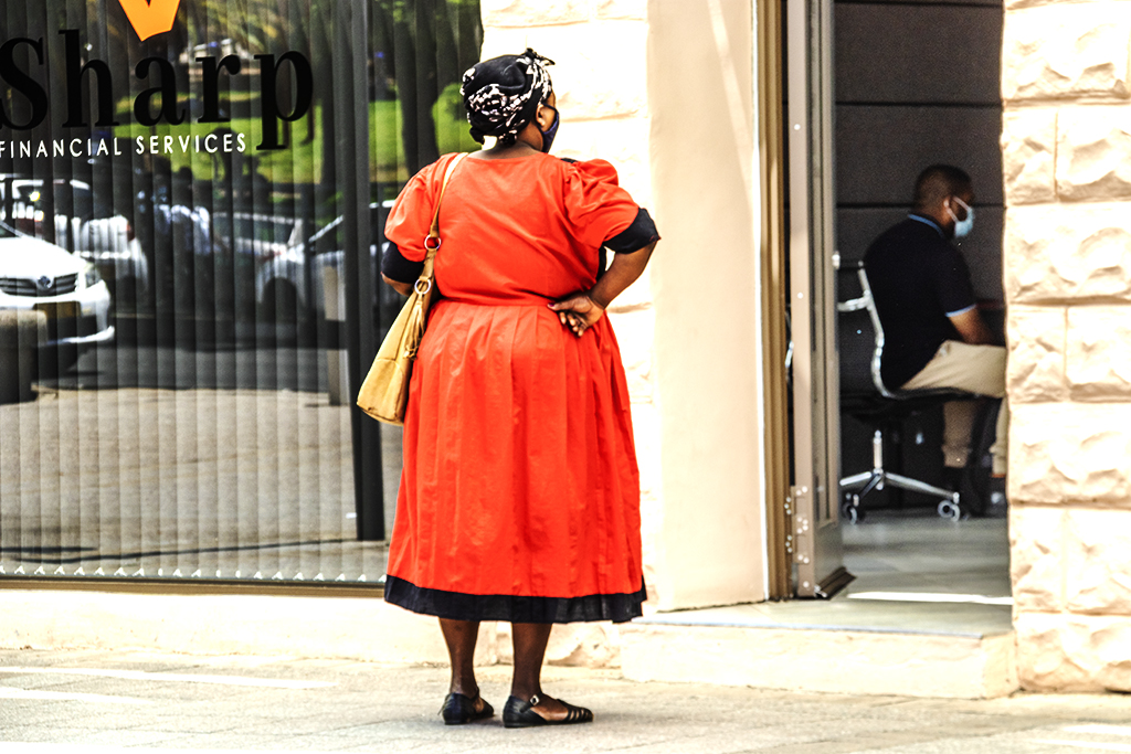 Woman in orange dress outside FINANCIAL SERVICES on 11-19-21--Windhoek copy