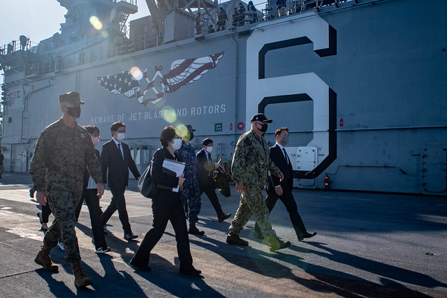Capt. Ken Ward, commanding officer of the forward-deployed amphibious assault ship USS America (LHA 6), second from right, leads a tour for local and regional civic and military leadership on the ship’s flight deck during a port visit to Marine Corps Air